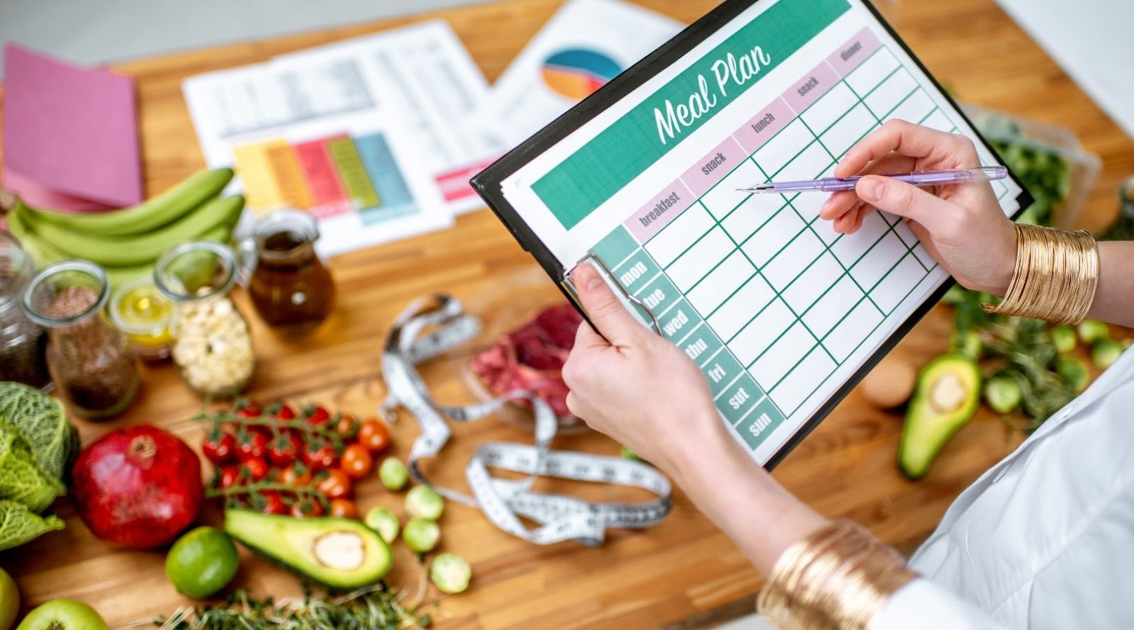 Toronto Nutritionist Dietitian writing a meal plan on the table filled with healthy foods