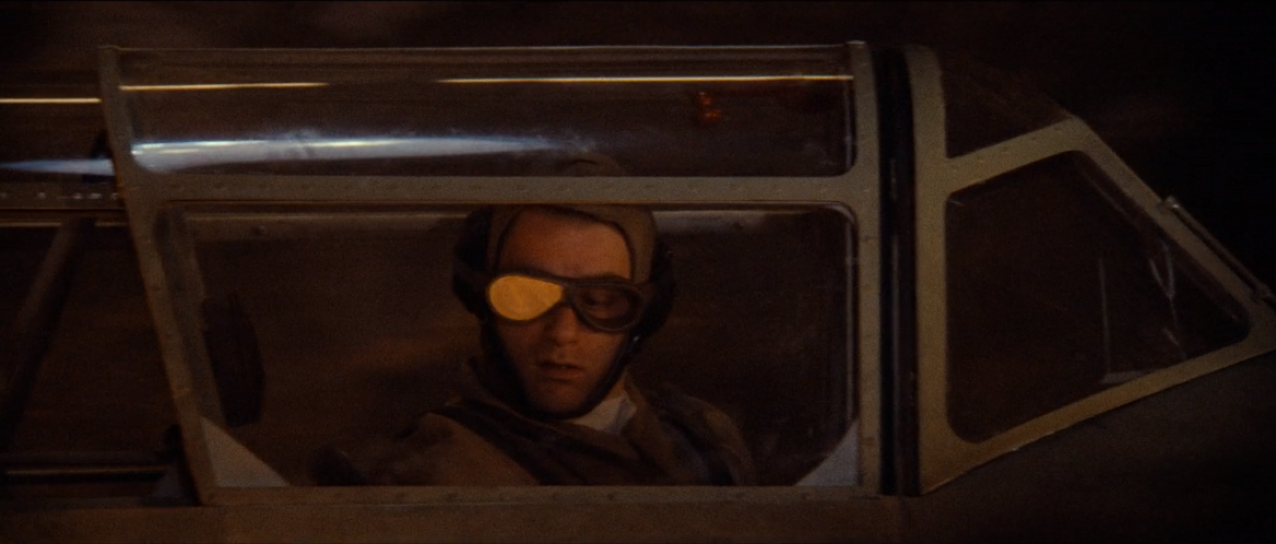 A Nazi fighter pilot stares in disbelief at the fire engorging his plane.