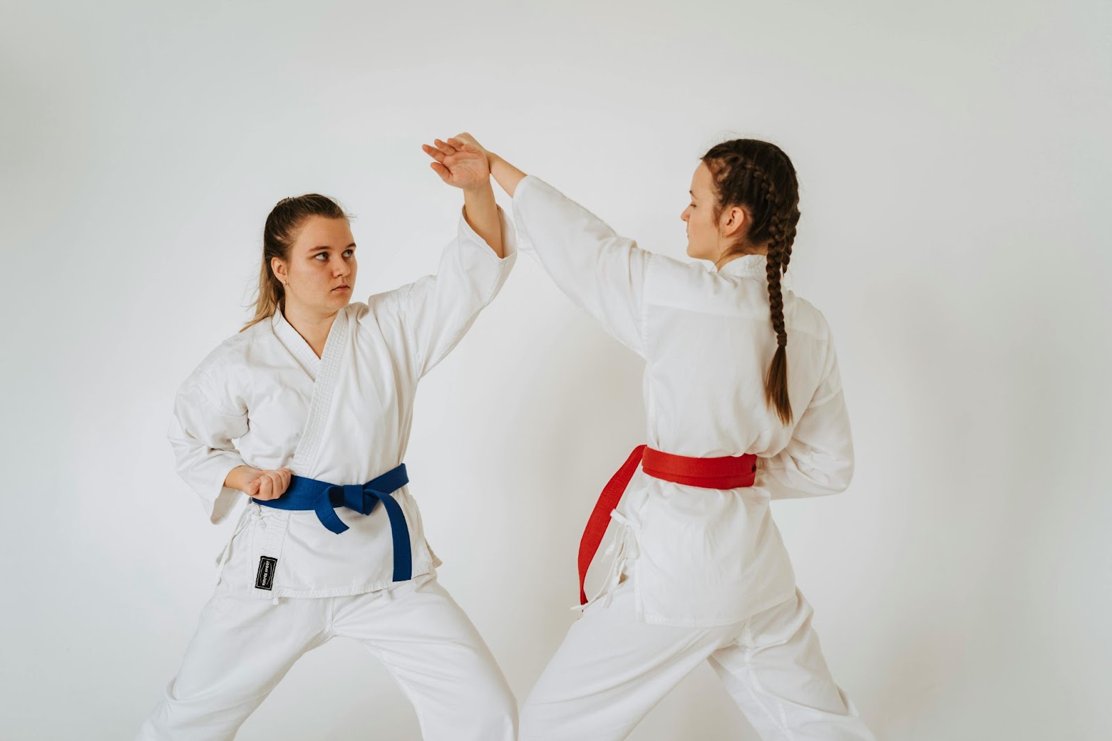 Two young female martial arts students practicing arm blocking techniques