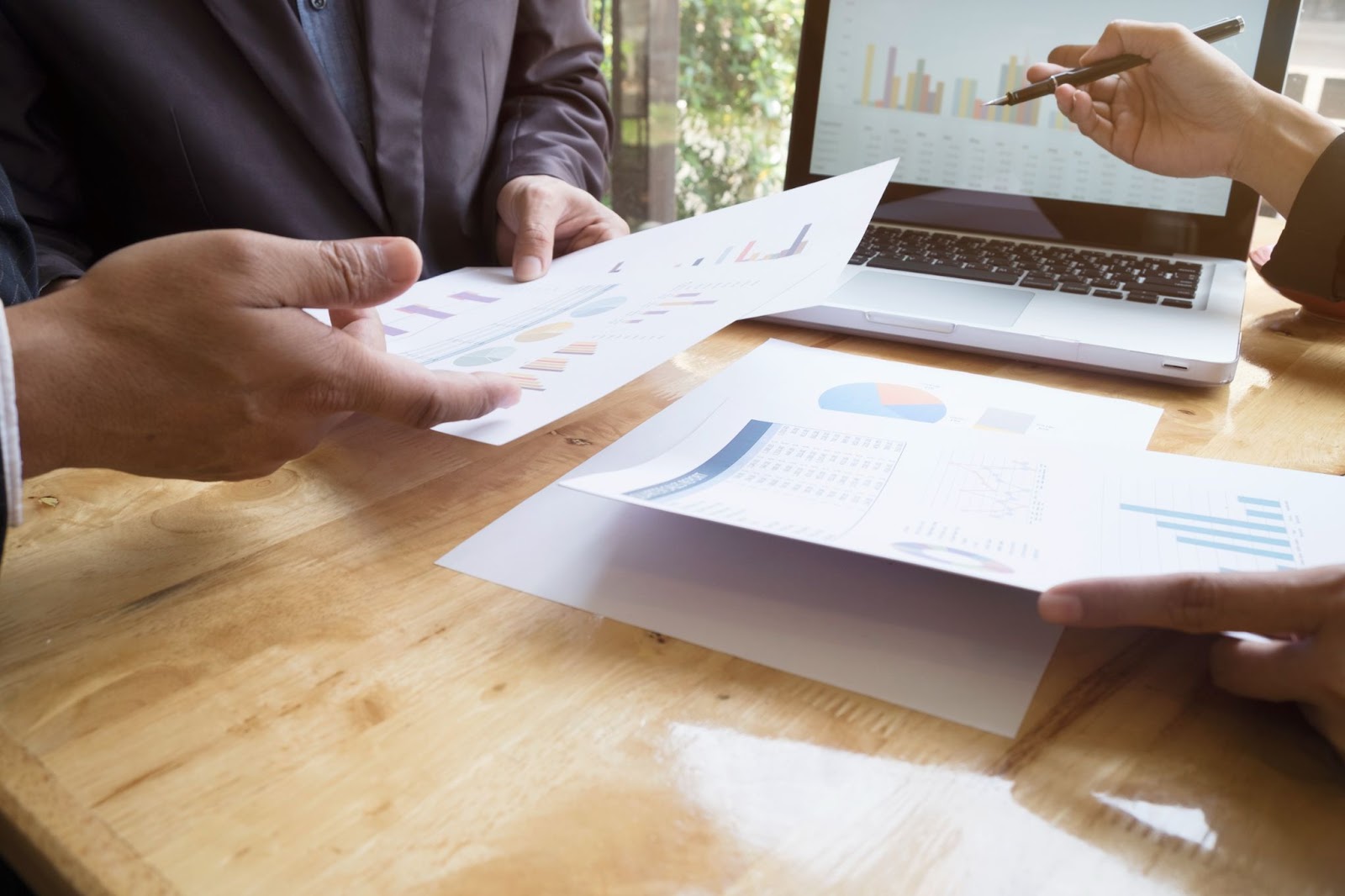 Dos personas están revisando y discutiendo informes financieros