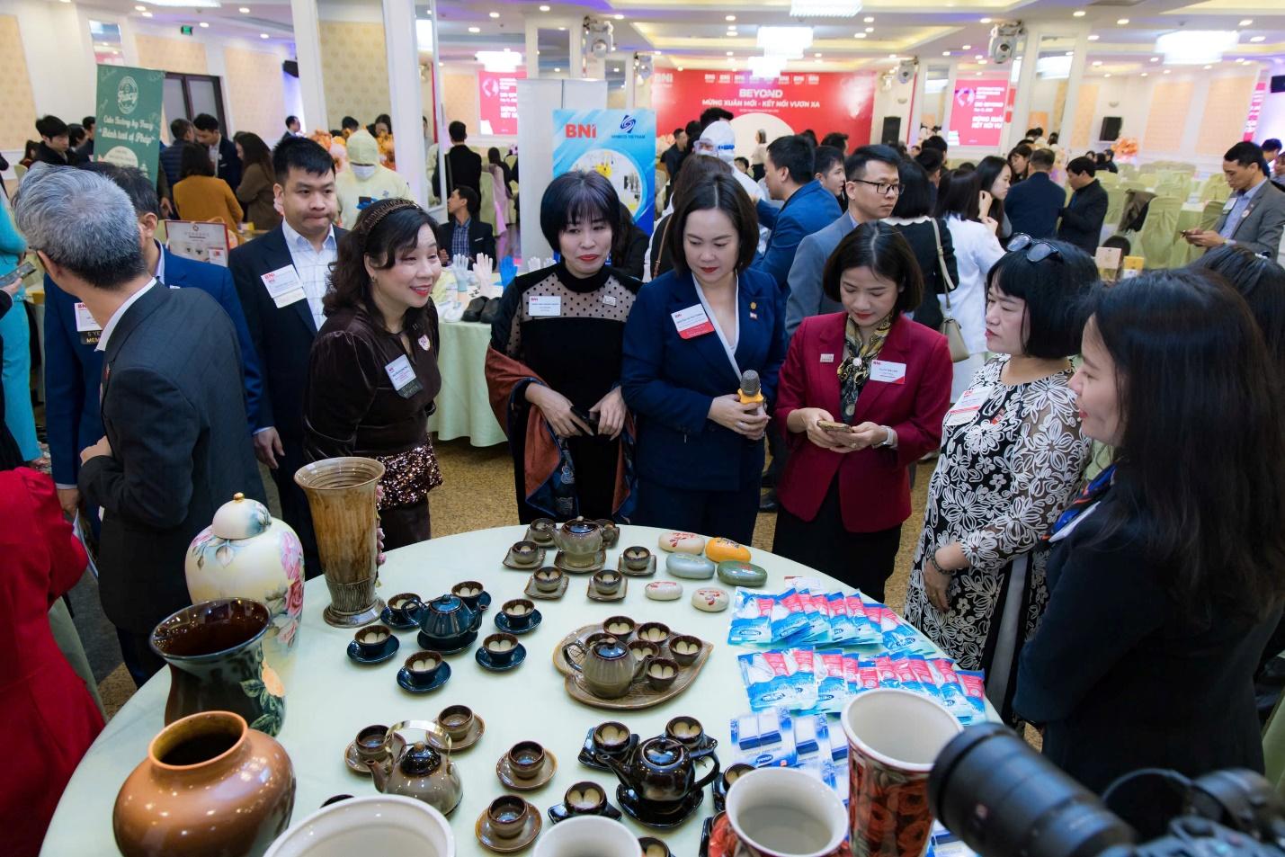 A group of people standing around a table with tea cupsAI-generated content may be incorrect.
