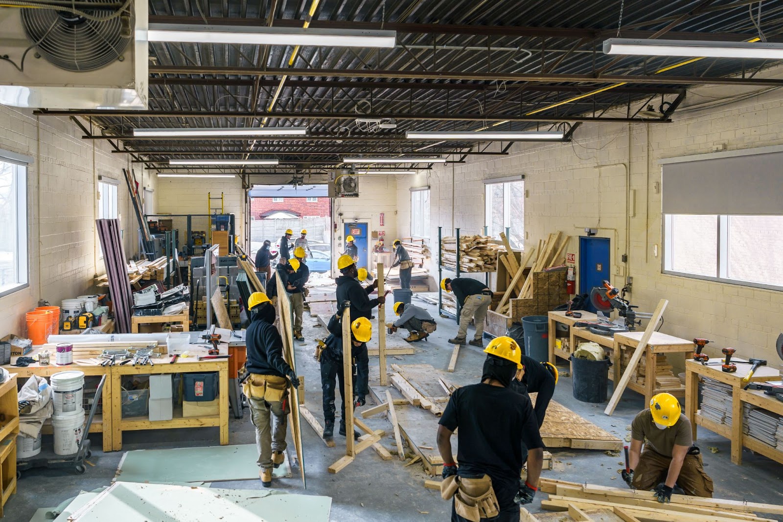 People wearing yellow hard hats working at a construction site. 