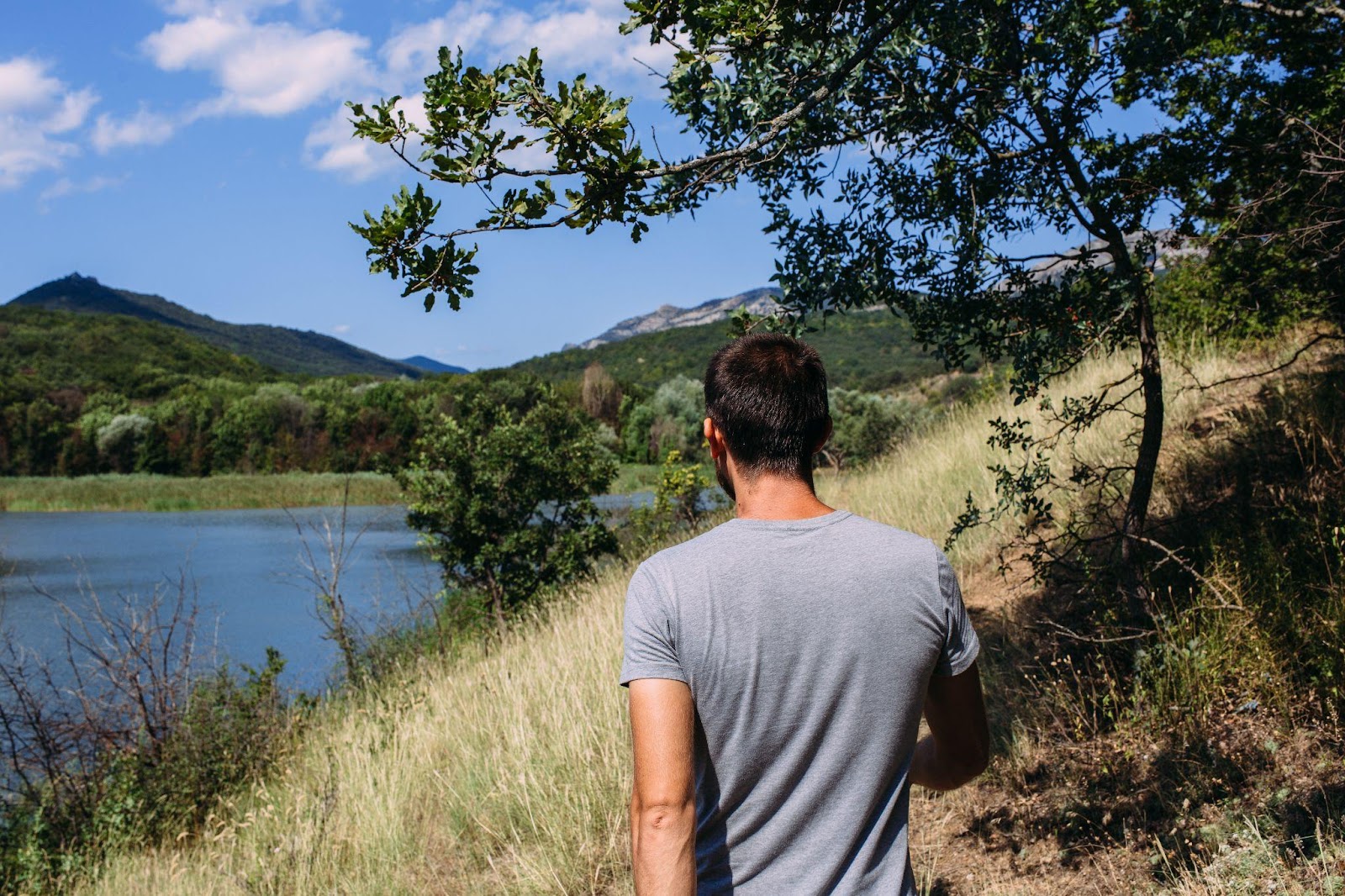 young man walking next to a lake