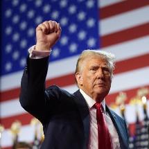 Donald Trump holds up his fist in a suit. 