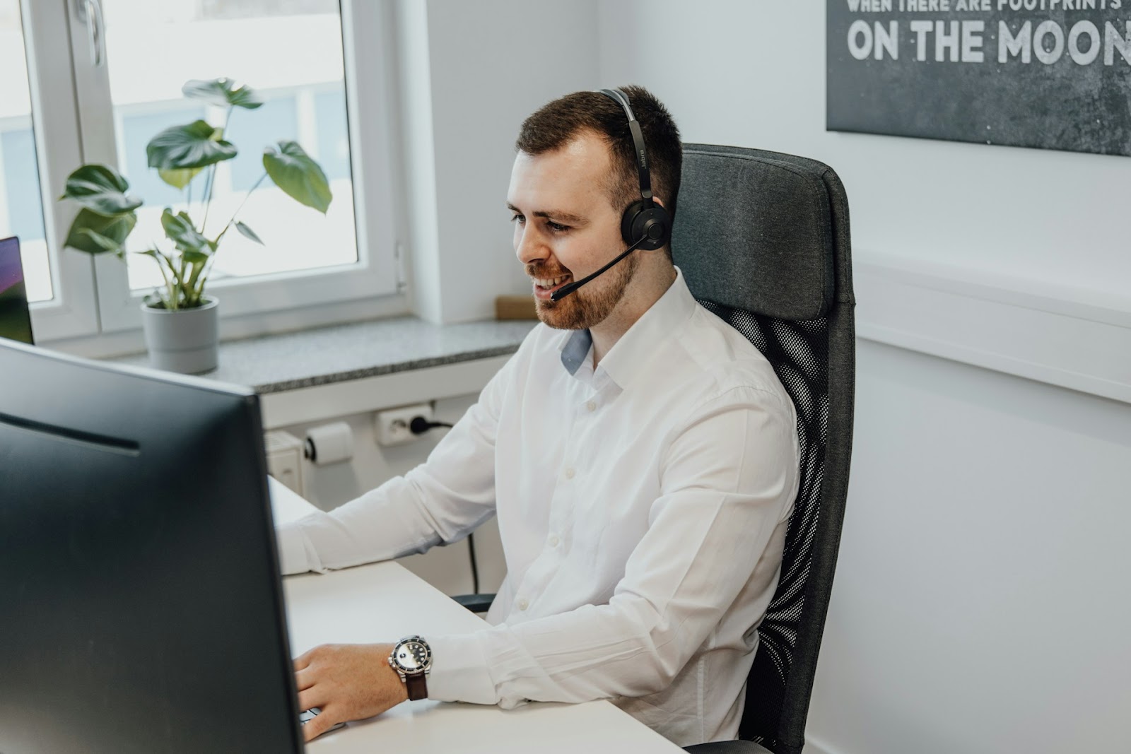 A man wearing a headset while working in an office set up