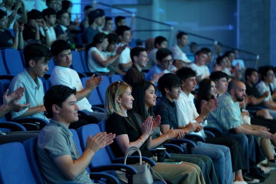 A group of people clapping in a auditoriumAI-generated content may be incorrect.