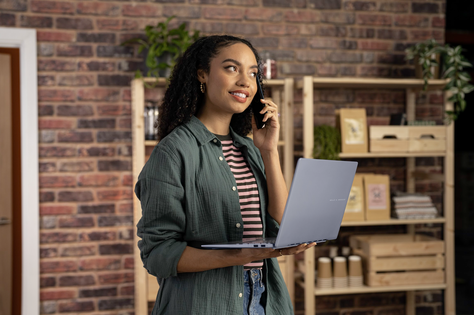 A person holding a computer and talking on the phone

Description automatically generated