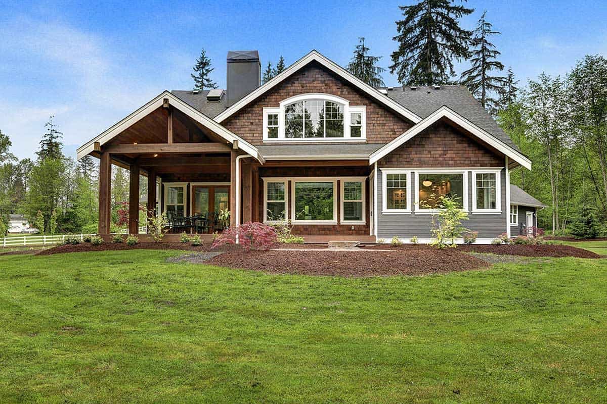 Rear exterior view showing the white-framed windows, gable rooflines, and a covered porch.
