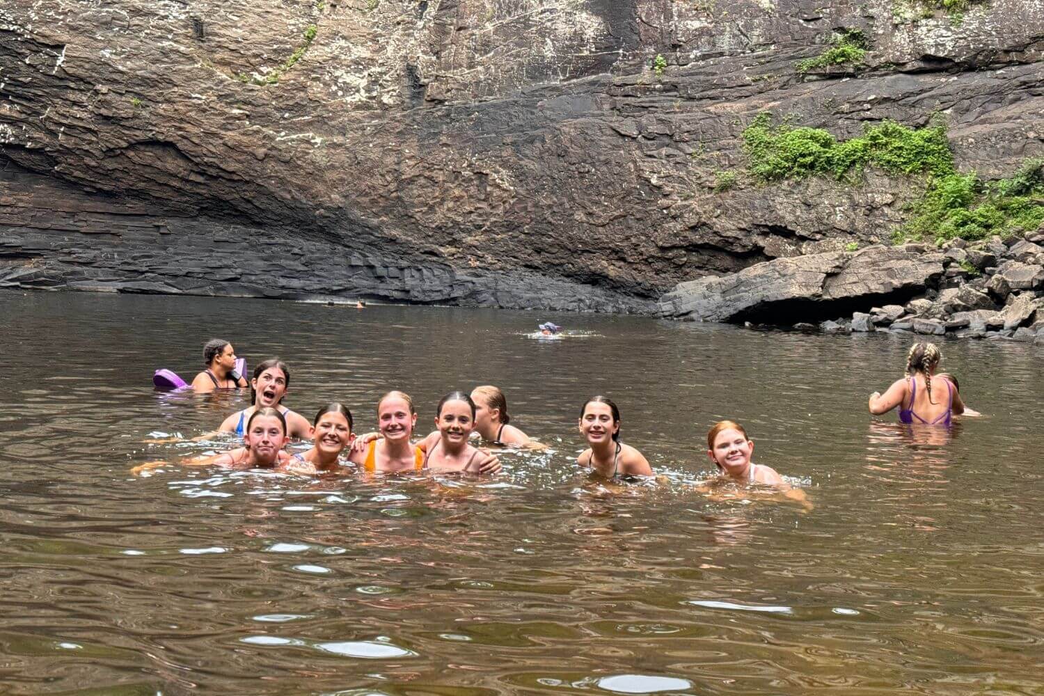 Group of girls swimming in a watering hole at Signature Sports Camp