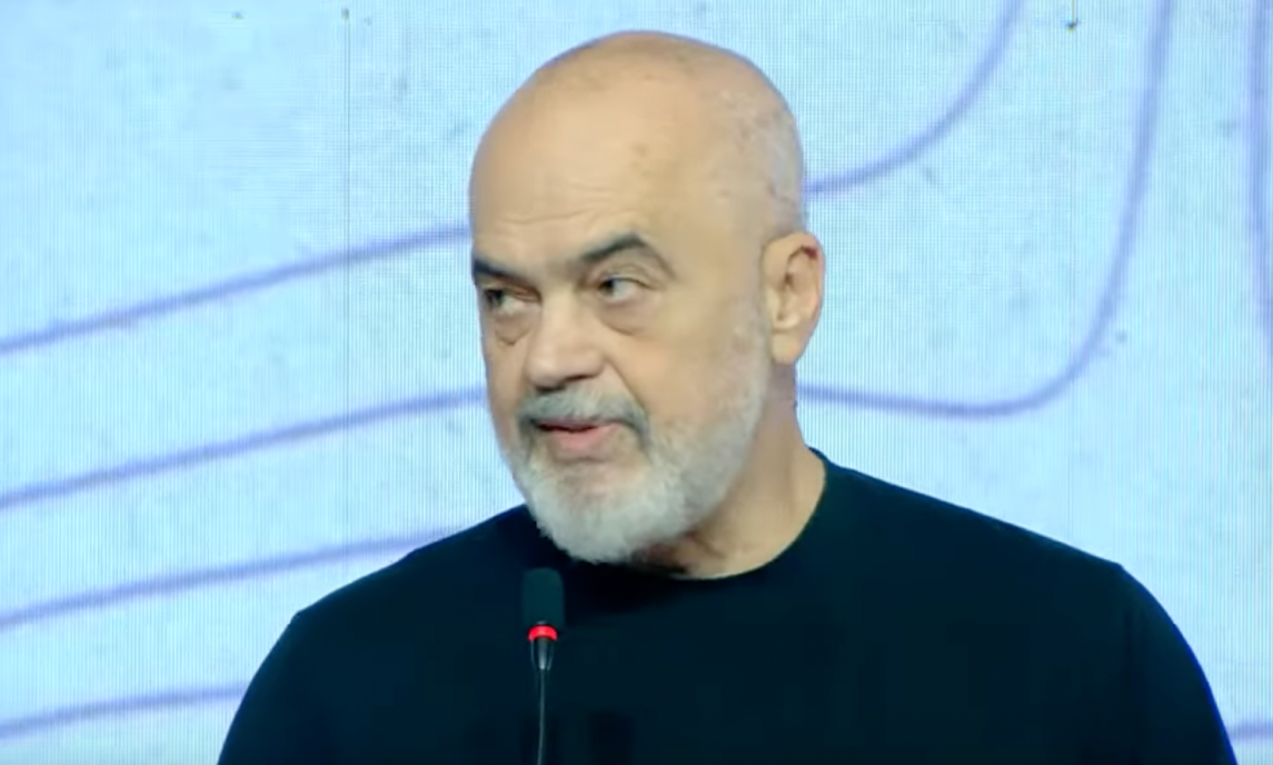 A person with a beard and mustache speaking into a microphone

AI-generated content may be incorrect.