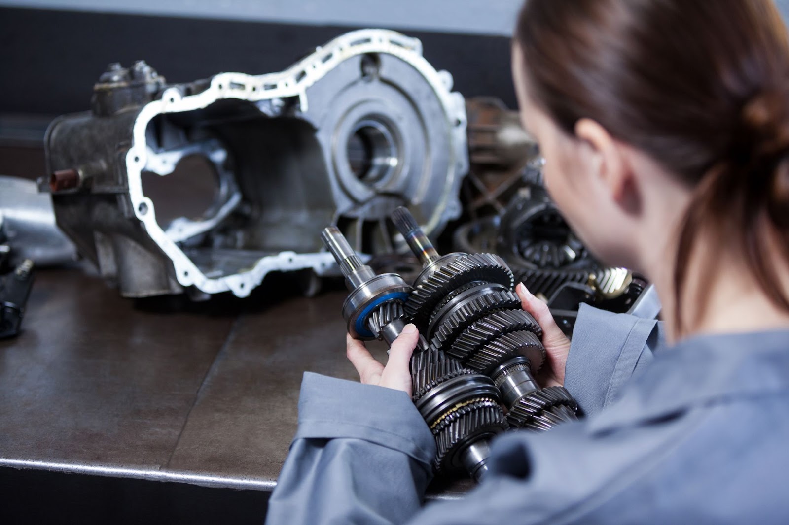 Female car mechanic checking car parts