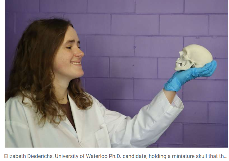 A person wearing a white coat and blue gloves holding a skull

Description automatically generated