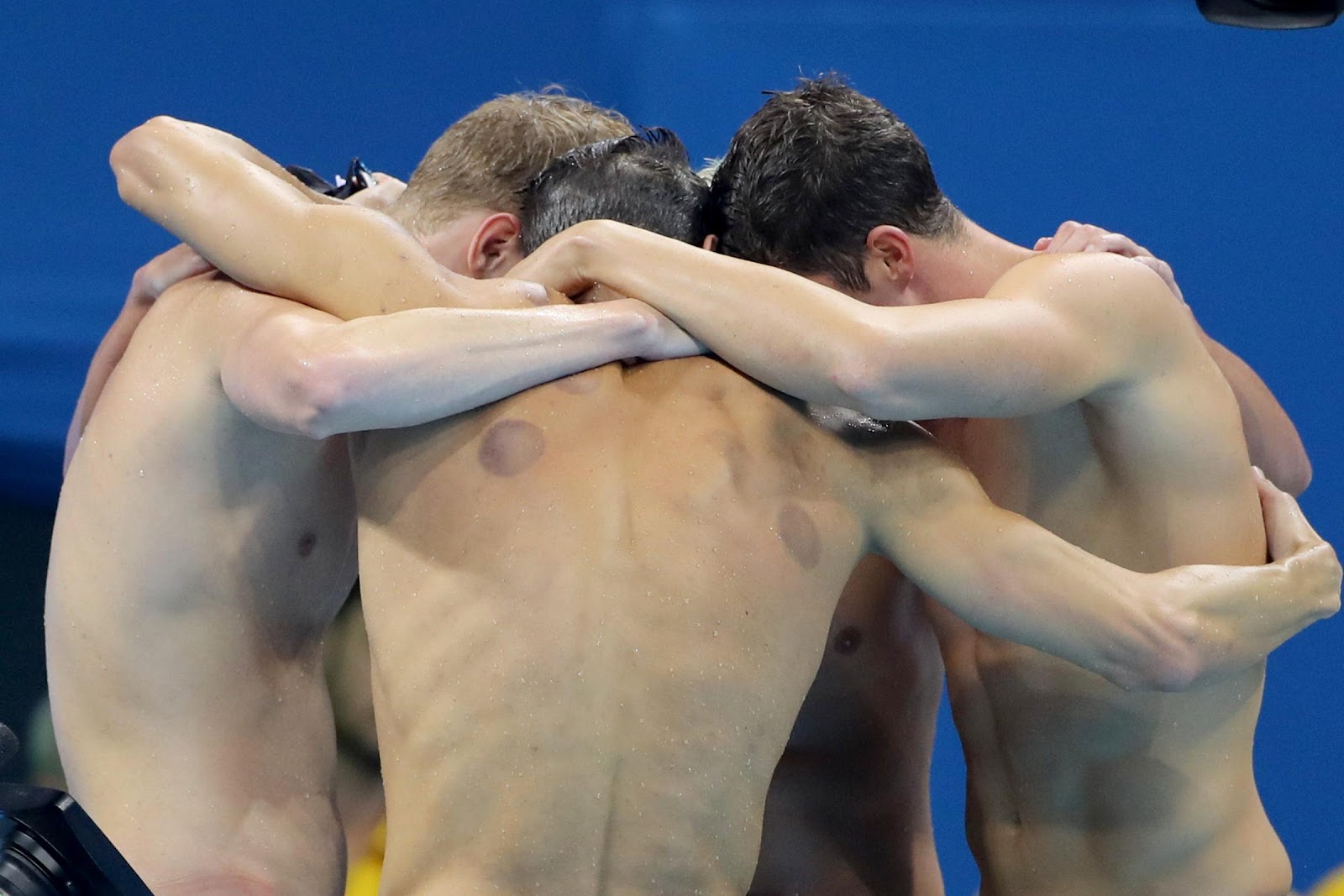 Conor Dwyer, Townley Hass, Ryan Lochte, and Michael Phelps embrace after winning the Men's 4 x 200m Freestyle Relay Final in Rio de Janeiro, Brazil, on August 9, 2016. | Source: Getty Images