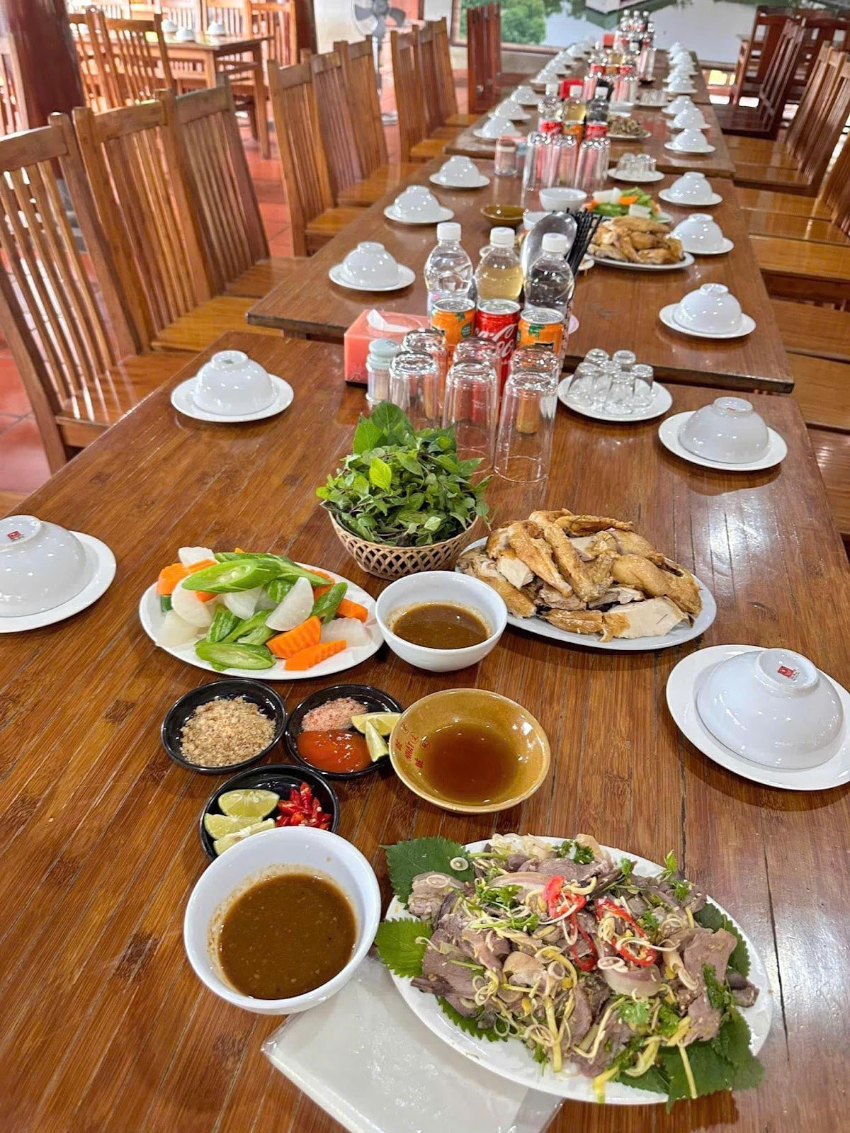 A long table with plates of food and drinks

Description automatically generated