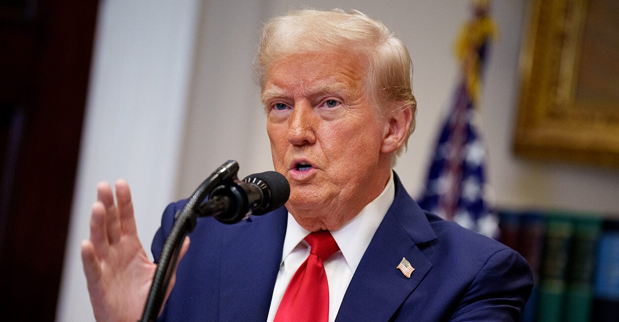 President Donald Trump gestures in a blue suit with a red tie