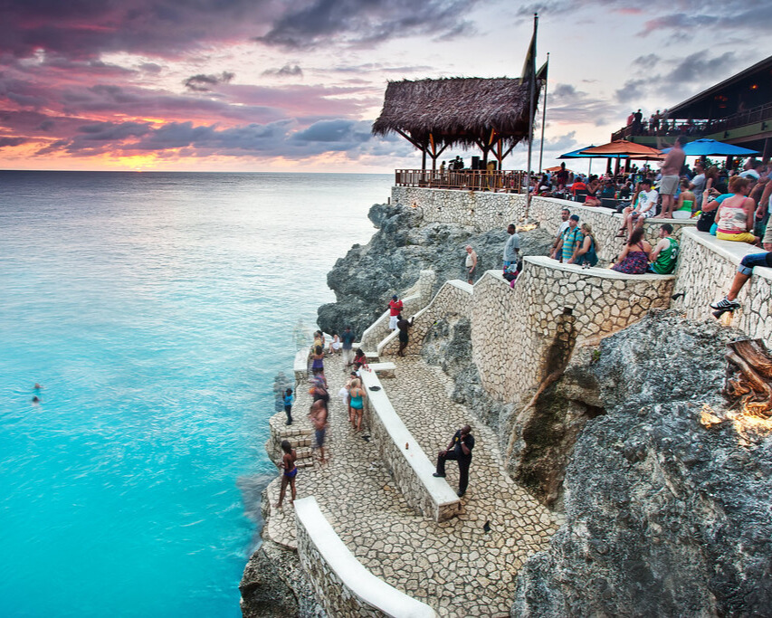 Ocean view in Jamaica with people walking along a pathway.