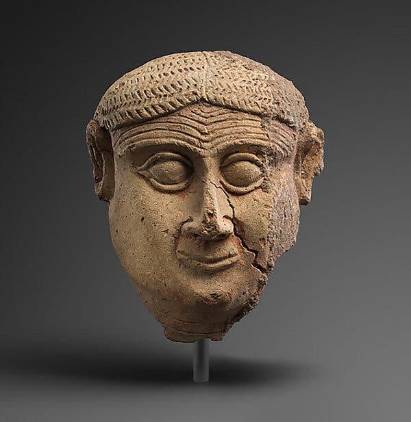 A sculpture of man wearing a slight grin.