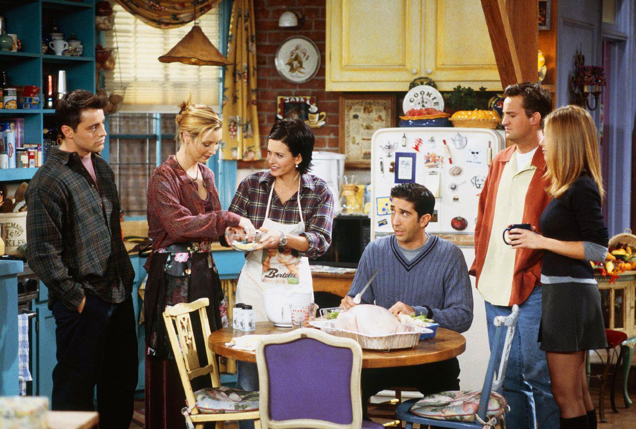 Elenco de Friends, la serie. En la foto, están incluidos Joey, Phoebe, Monica, Ross, Chandler y Rachel, reunidos en la icónica cocina del apartamento de Monica, compartiendo un momento casual.