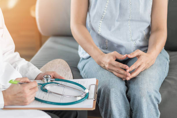 A pharmacist offering supplement advice to a perimenopausal woman, both engaged in a supportive consultation across the pharmacy counter.