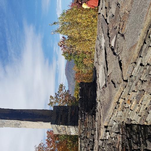 A stone structure with a tower in the background

AI-generated content may be incorrect.