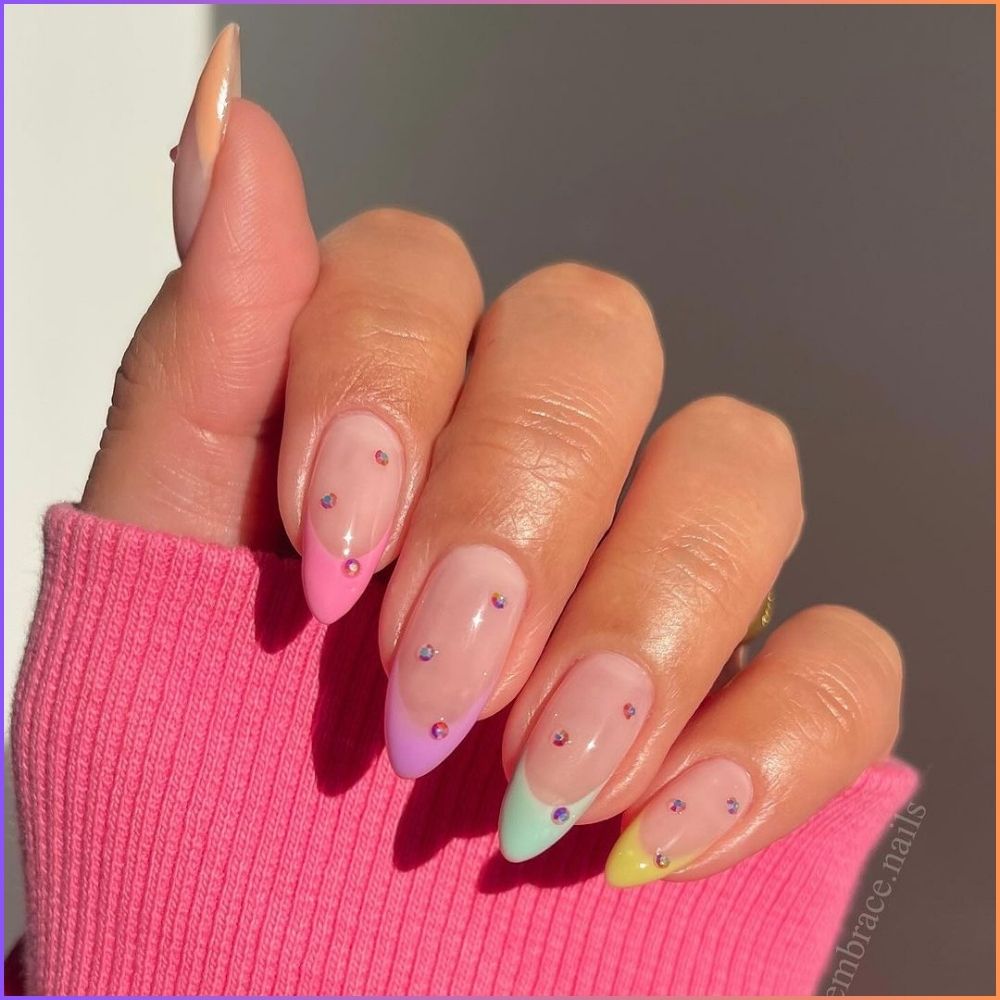 Zoom in view of hand with simple French tip nail having Soft color tips with rhinestones