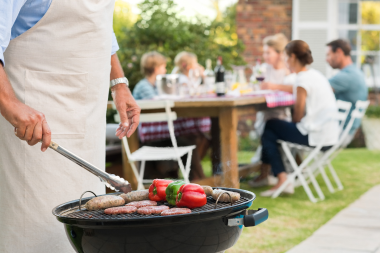 signs your outdoor living space is ready for a remodel homeowner grilling burgers and vegetables in backyard custom built michigan