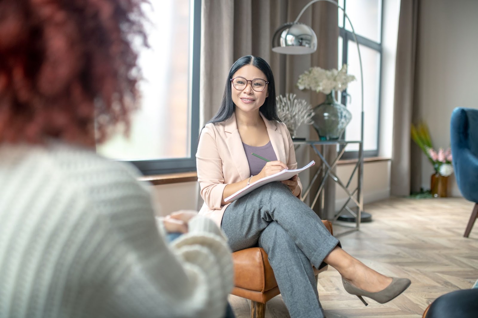 Woman sitting next to a therapist. 