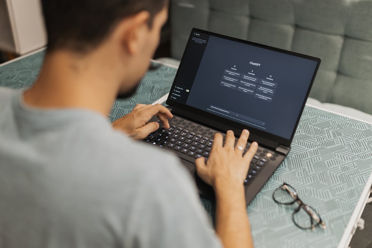 A man typing on a laptop using ChatGPT