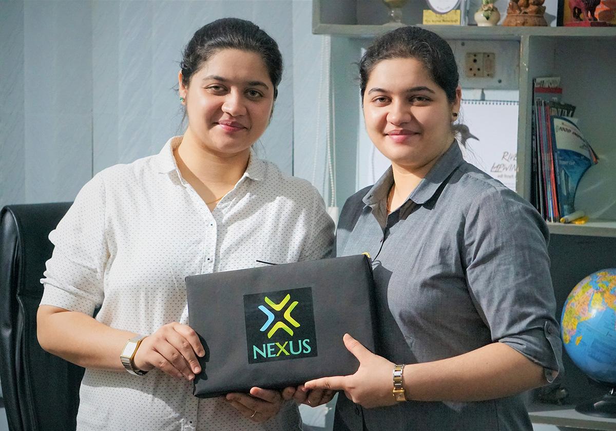 Nishita Baliarsingh and Nikita Baliarsingh holding the Nexus battery pack.