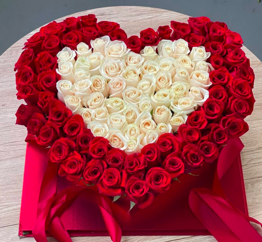 A stunning heart-shaped box overflowing with 110 red and white roses, beautifully arranged to convey love and affection in a romantic gift.