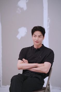 This contain Lee Min Ki  sitting in a chair with his arms crossed and looking at the camera