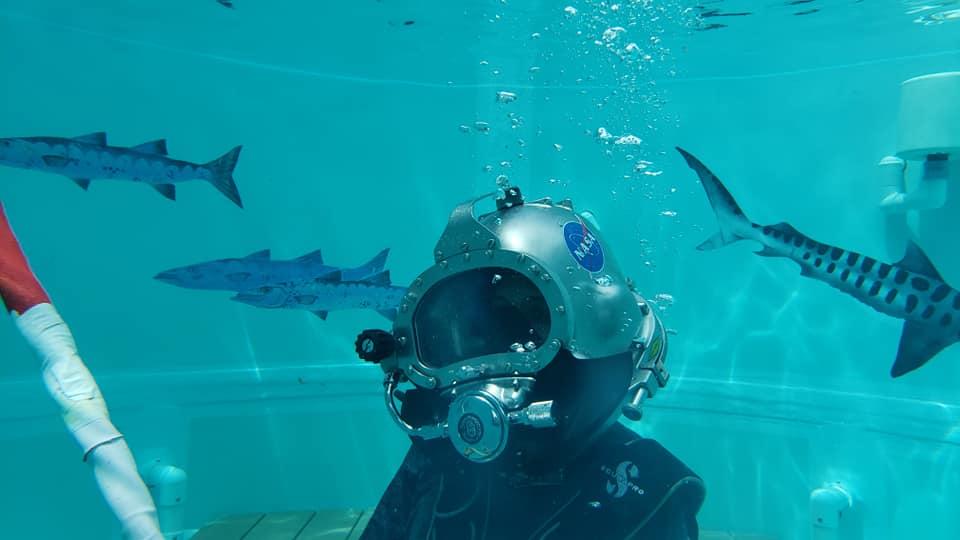 Caption: Dr. Shawna Pandya tries on a Kirby-Morgan helmet during her Dive Medical Technician training at the Aquarius Reef Base