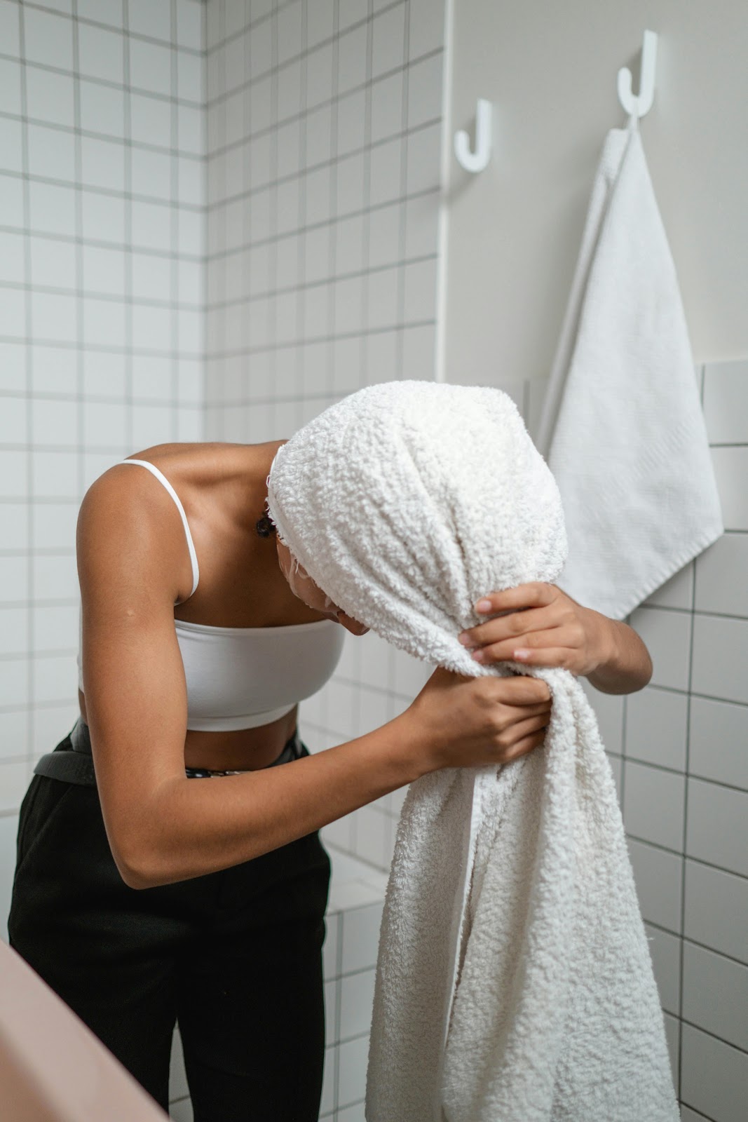 A lady drying her hair with a microfiber towel