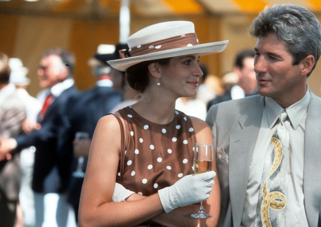 Julia Roberts boit un verre avec Richard Gere dans une scène du film "Pretty Woman", 1990.