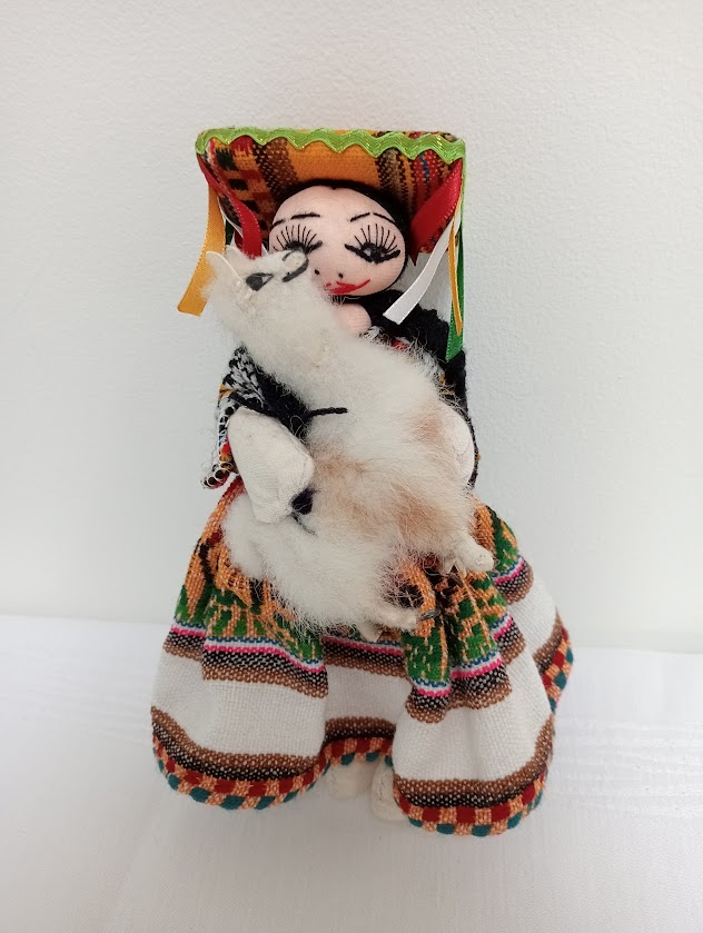 A cloth doll of a Peruvian woman holding a llama