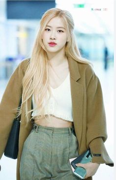 A picture of BLACKPINK Rosé's on a white dress and a brown jacket and gray trouser 