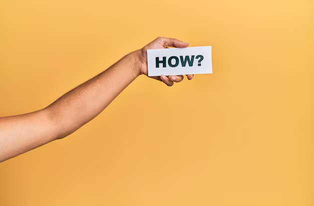 A hand holding a card with the word "how" written on it