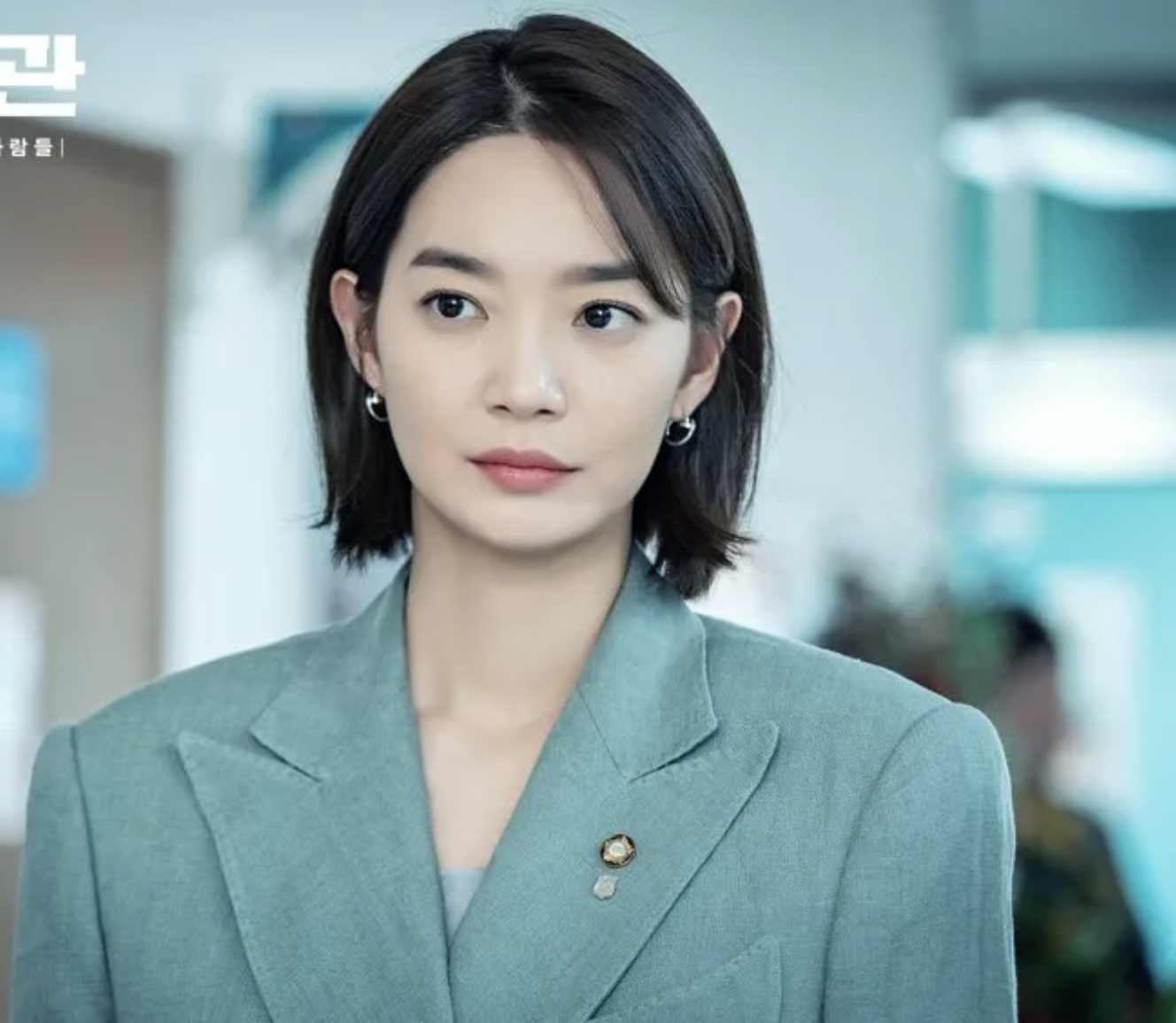 A picture of Shin Min Ah putting on a gray suit 