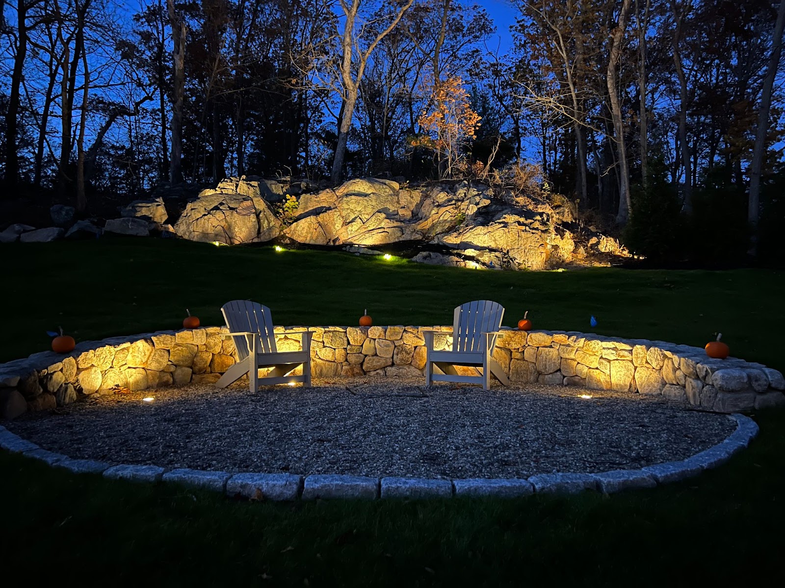 Strategically placed flush mount lighting lights up the firepit area, thanks to a thoughtful outdoor lighting design