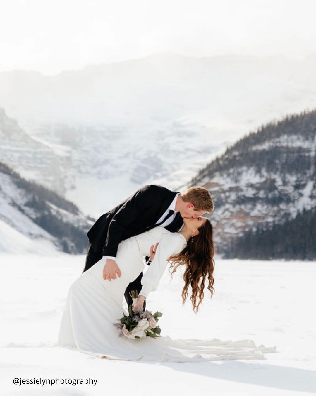 winter engagement photos couple kissing in the snow