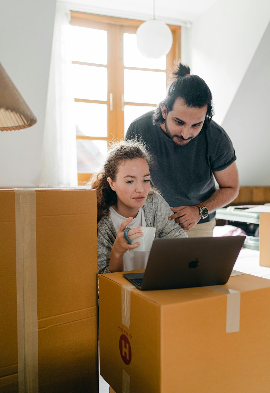 Couple looking at laptop on top of boxes