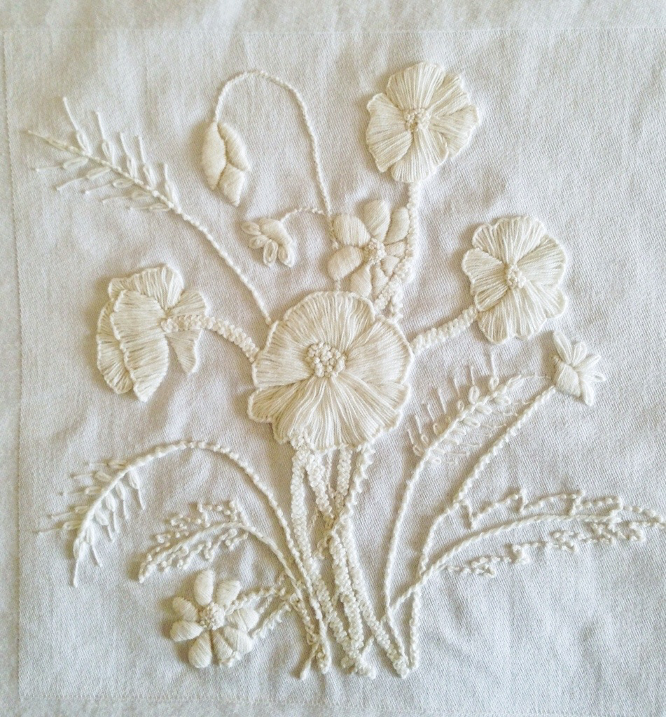 A white embroidered flower on a white cloth

Description automatically generated