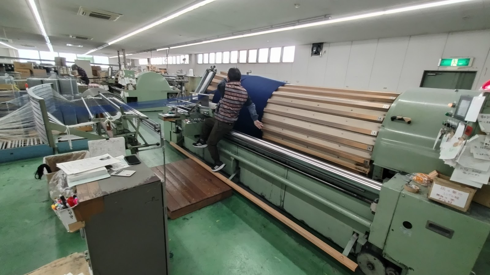 A worker using a machine to weave ramie yarn into fabric.