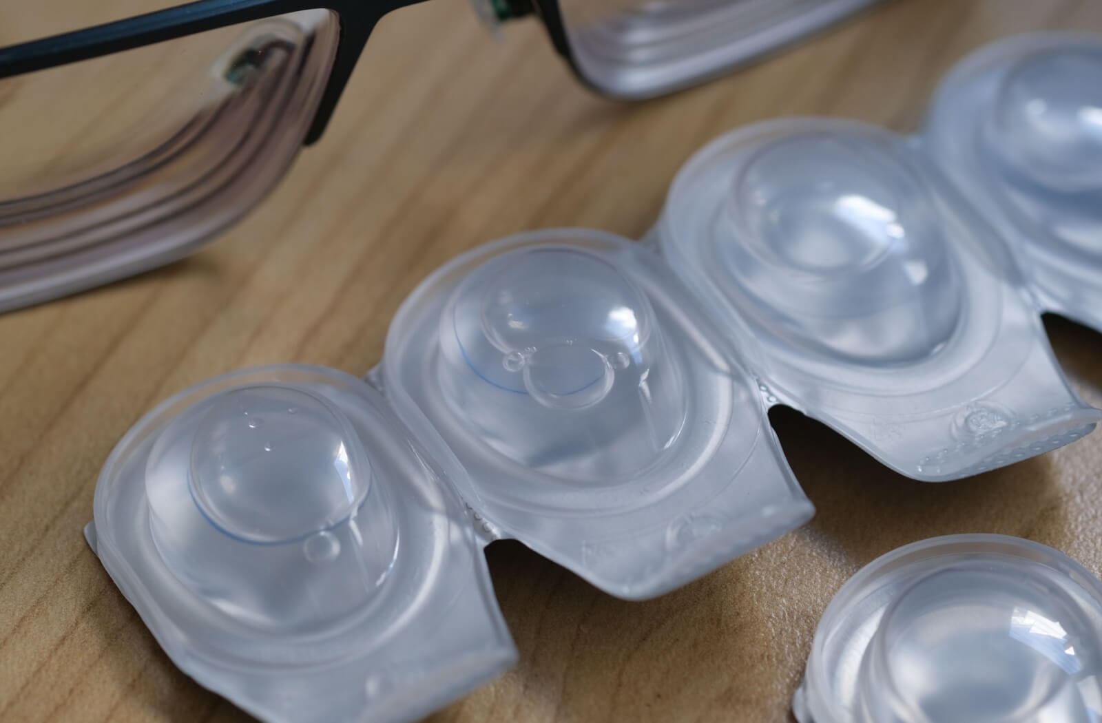 A close-up image of a row of daily disposable contact lenses in their individual packaging for ease of travel.