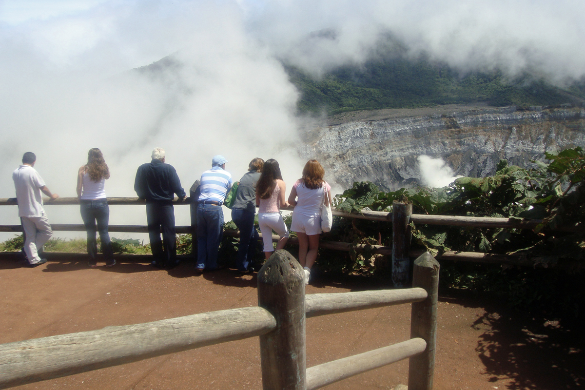 Tourist viewing Poás Volcano from a lookout point.