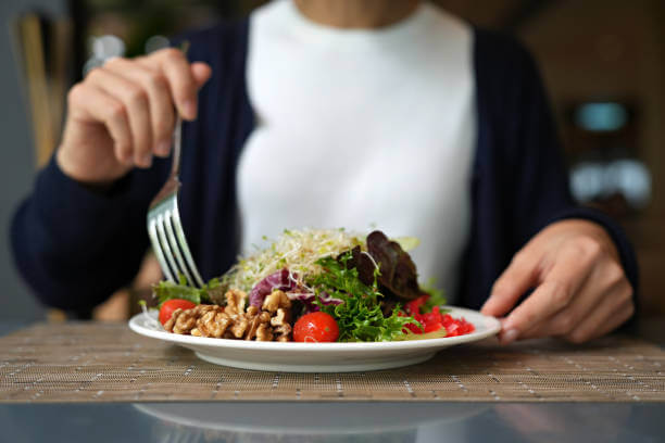 A person enjoying a nutritious meal with fresh vegetables and grains, highlighting the importance of a healthy diet for gut health.