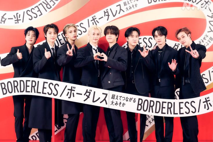 This contain: a group of men standing next to each other on a red and white background with the words borderless