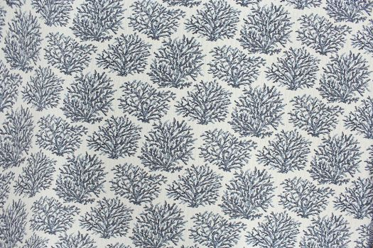 A close-up of Revolution fabric with a blue coral print on a light beige background.