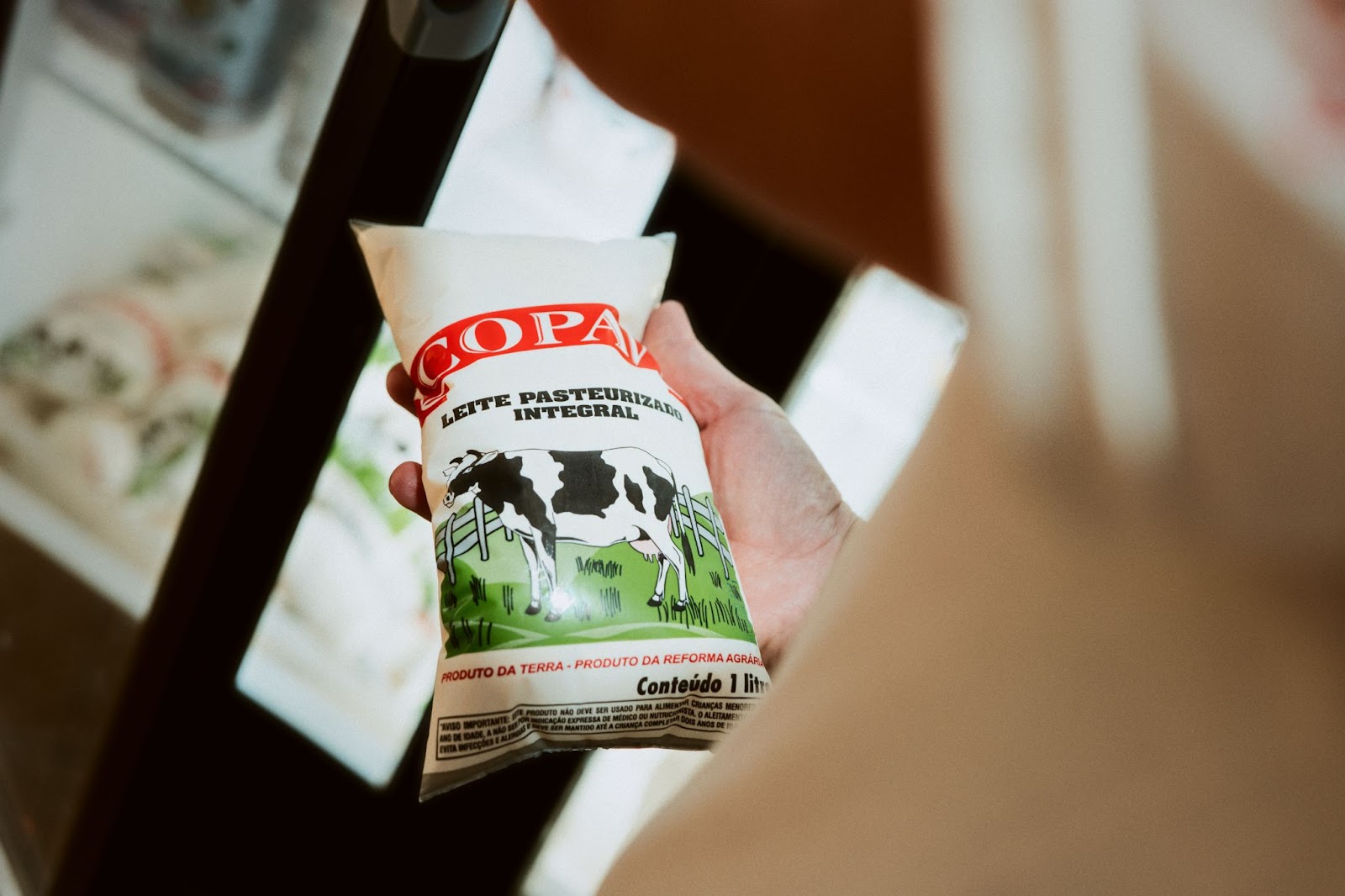 A imagem mostra um saquinho de leite pasteurizado integral produzido pela Copavi. 