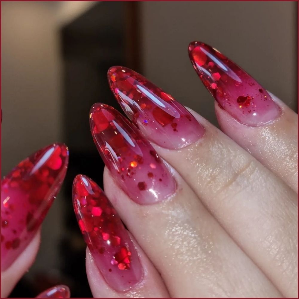 Close up of hands having Christmas red nails with Sparkling Red Gradient